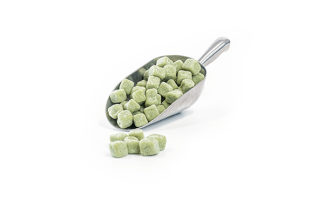 Green mint fudge pieces in stainless steel scoop on white background.