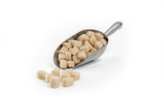 White Choc Fudge Pieces in stainless steel scoop on white background